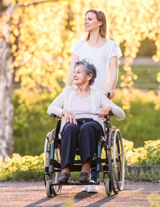 elder woman on wheelchair assisted by caregiver